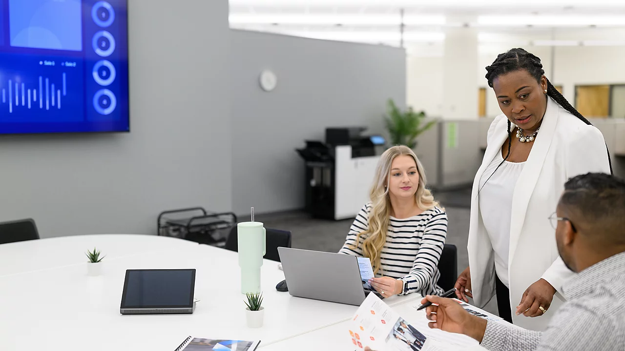 PR_CX963xse-CX963se-XC9655-XC9645-XC9635_Right_ENV_three-people-discussing-with-printer-in-the-background PR_CX963xse-CX963se-XC9655-XC9645-XC9635_Right_ENV_three-people-discussing-with-printer-in-the-background